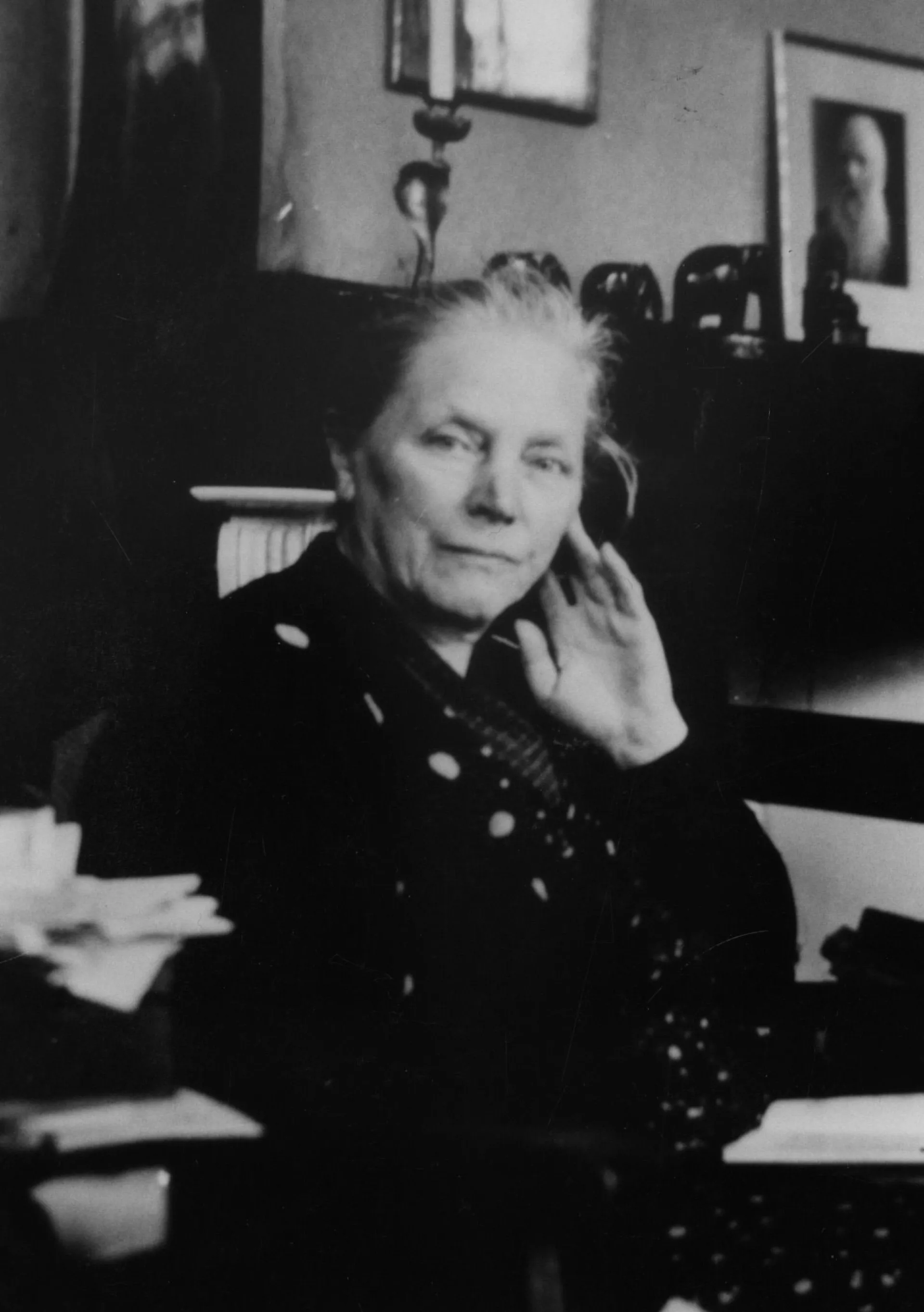 Portretfoto, zwart-wit van Gesina Bahler-Boerma. Ze houdt haar hand naast haar gezicht en kijkt in de camera. 