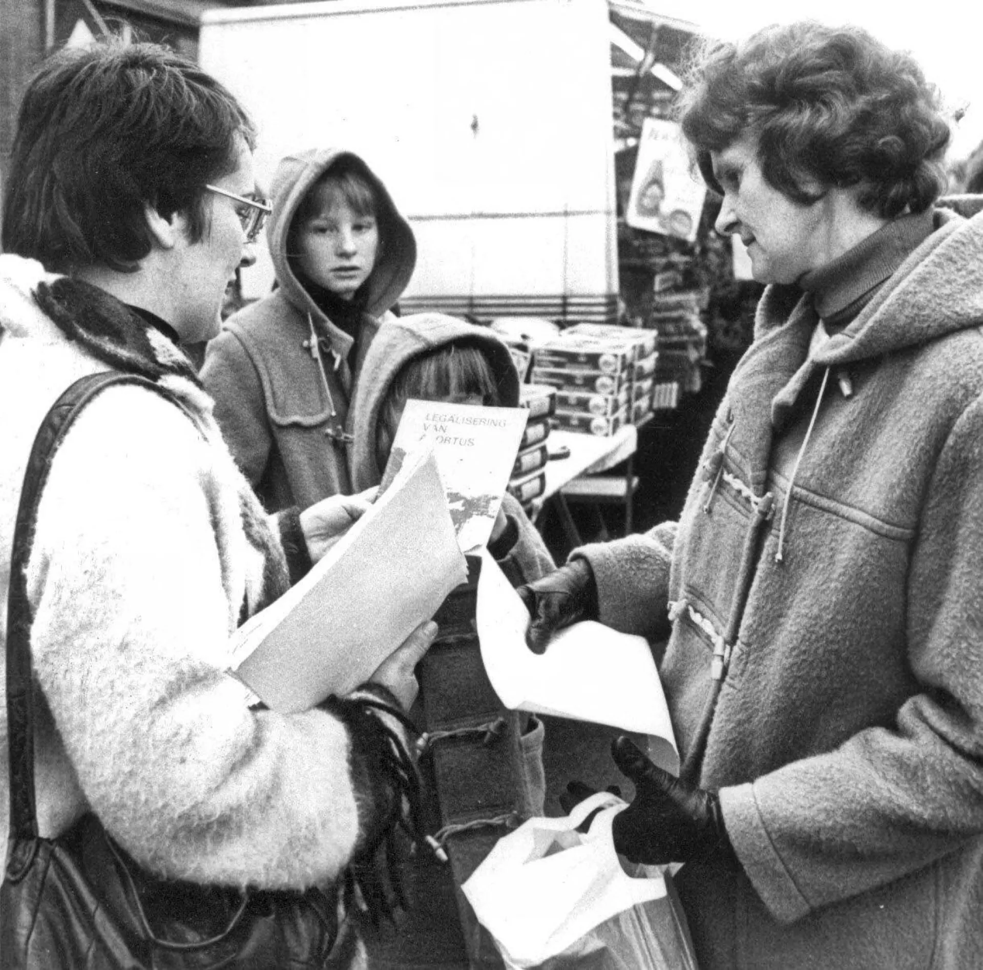 Zwart-wit foto op een markt. Vrouwen houden een enquête over de legaliseren van abortus, in Assen.